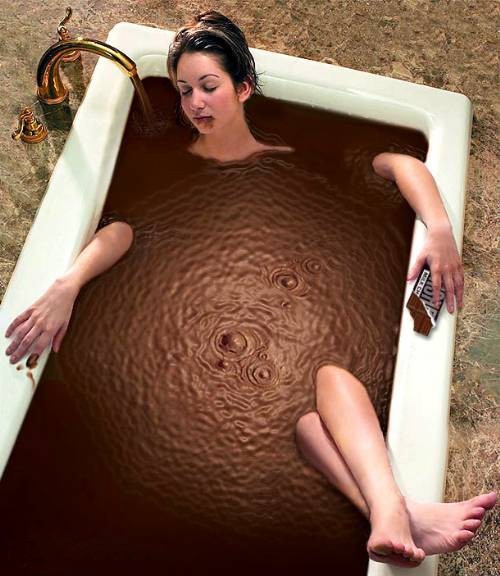 Девушка с шоколадкой в ванной наполненной шоколадом